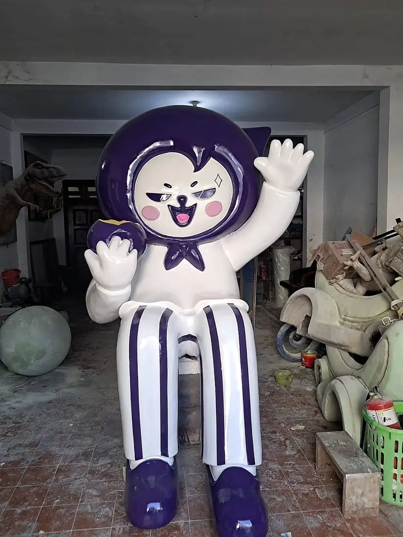 Patung karakter maskot duduk berpakaian bergaris