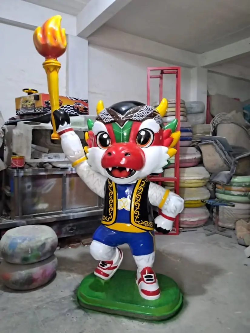 Patung maskot naga merah membawa obor
