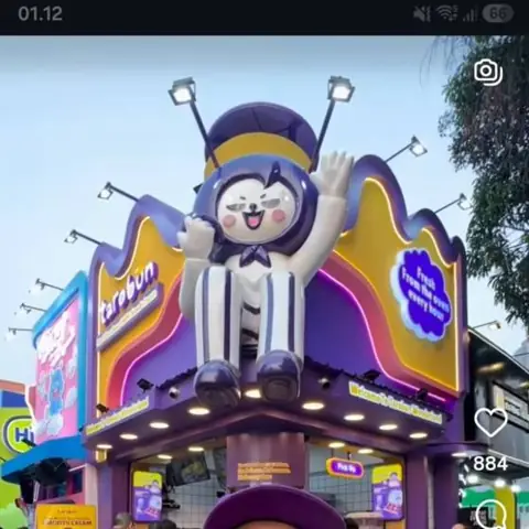Patung maskot raksasa di atas gerai makanan