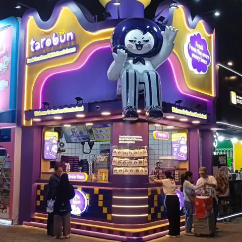 Gerai makanan dengan patung maskot di pameran