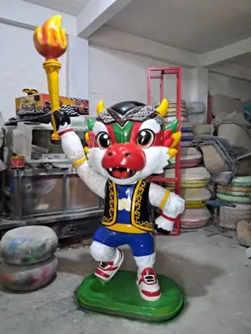 Patung maskot naga merah membawa obor