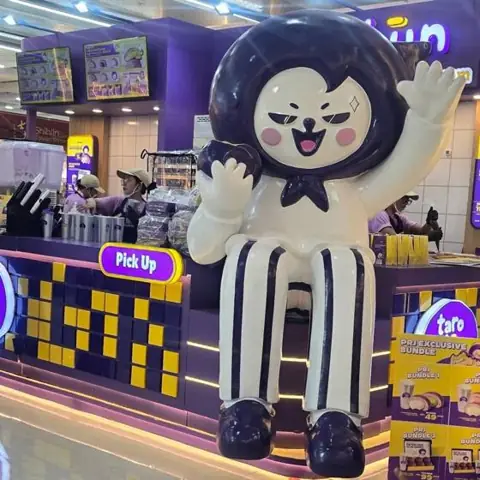 Gerai makanan dengan patung maskot duduk di atasnya